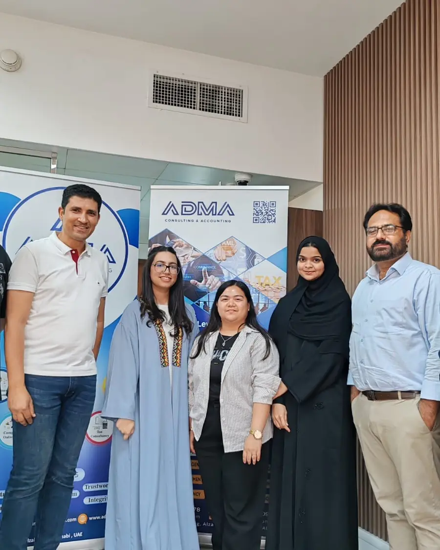 The ADMA team beside their banners